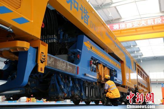 圖為工人正在清理大型養(yǎng)路機械?！堖h 攝